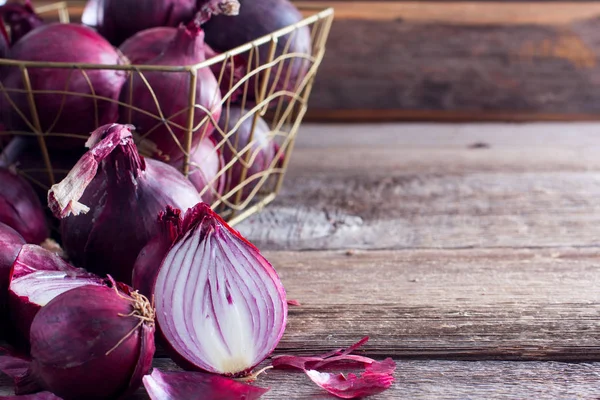 Red onions cut in half on a wooden table, copy space, horizontal