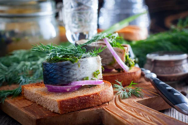 Marinated herring with dill on black bread with onion, selective focus — Stock Photo, Image
