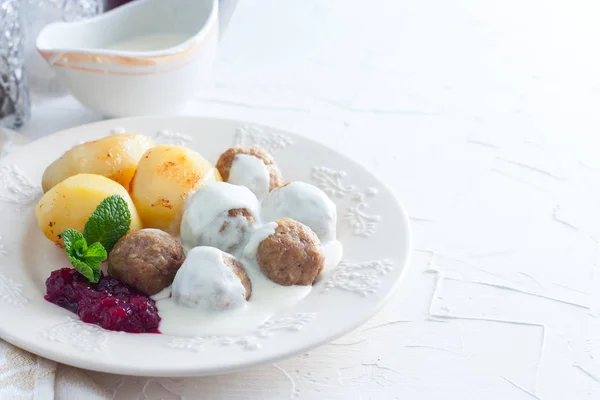 Шведские фрикадельки со сливочным соусом, вареная картошка и клюквенное варенье, горизонтальное, копировальное пространство — стоковое фото