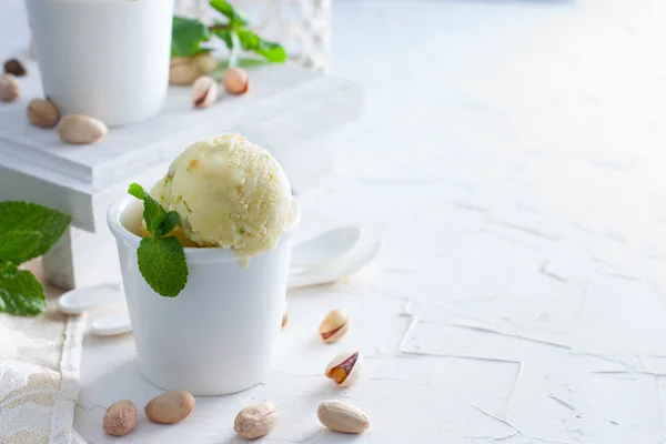 Домашнее фисташковое мороженое в белых керамических чашках на белом столе, пространство для копирования — стоковое фото