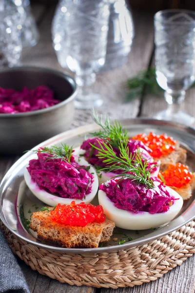 Lanche de ovos recheados com beterraba e peixe enchendo em uma mesa de madeira, estilo rústico, foco seletivo — Fotografia de Stock