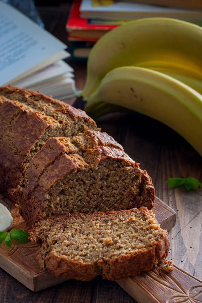 Pastel de plátano en rodajas con harina integral en una tabla de madera, enfoque selectivo — Foto de Stock