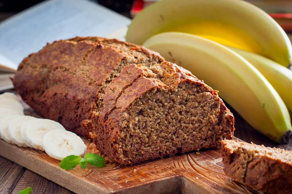 Pastel de plátano en rodajas con harina integral en una tabla de madera, enfoque selectivo — Foto de Stock