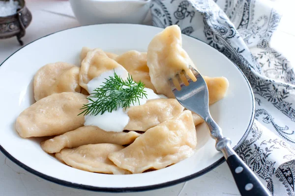 Dumplings met kaas en brandnetels in een traditionele keramische plaat. Russische traditionele keuken — Stockfoto