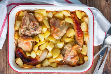 Sosis ve bir ahşap masa, üstten görünüm, yatay emaye formunda tavuk fırında patates