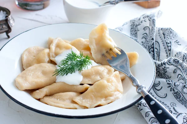 Dumplings met kaas en brandnetels in een traditionele keramische plaat. Russische traditionele keuken — Stockfoto