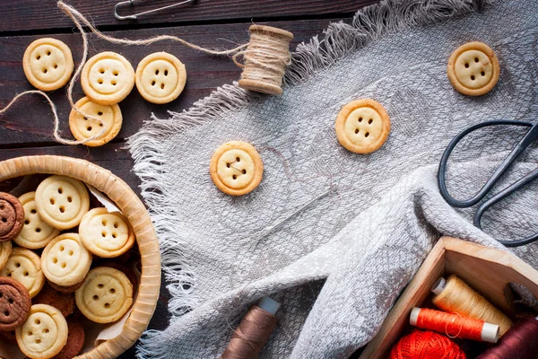 Homemade cookies in the form of buttons, imitation of the sewing process of buttons, top view, horizontal