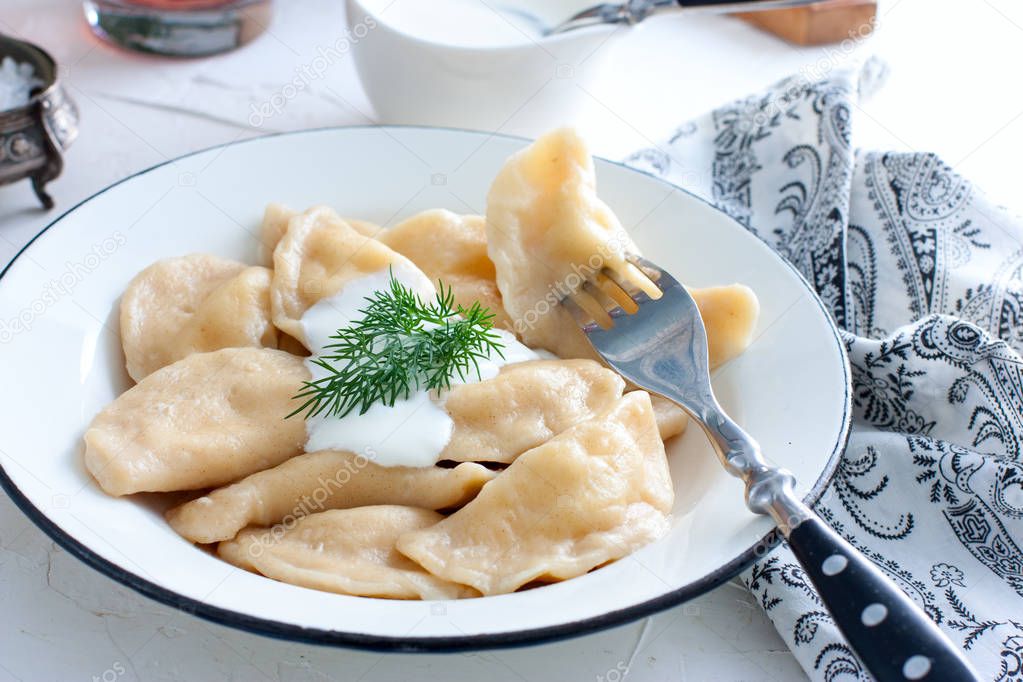 Dumplings with cheese and nettles in a traditional ceramic plate. Russian traditional cuisine