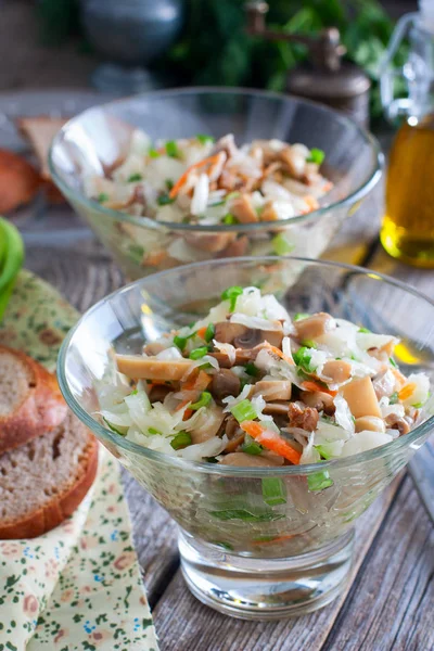 Салат из квашеной капусты и грибов в стеклянных мисках, избирательный фокус — стоковое фото