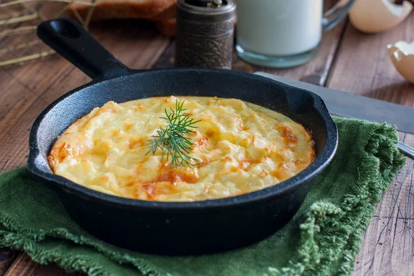 Aardappel braadpan in een gietijzeren koekenpan op een houten tafel, horizontale — Stockfoto