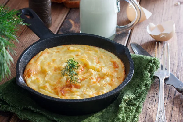 Aardappel braadpan in een gietijzeren koekenpan op een houten tafel, horizontale — Stockfoto