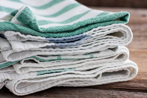 Clean washed kitchen towels stacked on a wooden table, copy space — Stock Photo, Image