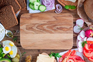 Açık sandviçler (Smarrebrod) taze sebze, kırmızı balık, karides, yumurta, peynir, ringa balığı ve Yeşiller ile siyah ekmek üzerinde hazırlanması için malzemeler. Görünümü, yatay üst, alanı Kopyala.