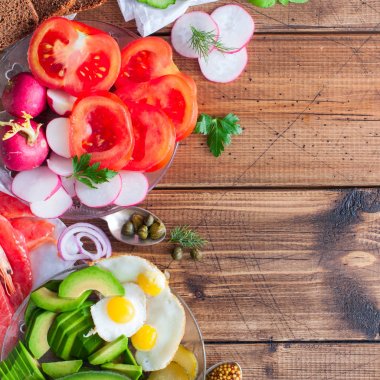 Taze sebze, kırmızı balık, karides, yumurta, peynir, ringa balığı ve Yeşiller ile kahvaltı sandviç için malzemeler. Üstten Görünüm, kare