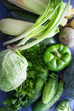 Taze yeşil sebze ve gölgeler (lahana, perez, taze yeşillik, kabak, kereviz, soğan, brokoli, salatalık, turp), masada en iyi görünümü