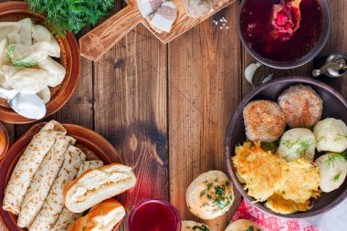 Ahşap bir masa - borsch, vareniki, pampushki sarımsak, domuz yağı, krep, patates, vvar, üstten görünüm, yatay, Ukrayna mutfağından geleneksel yemekleri alanı Kopyala