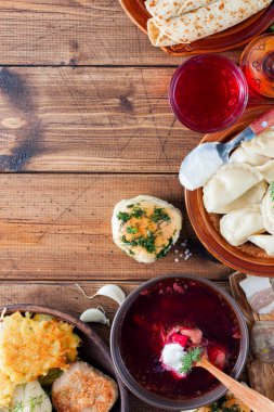 Ahşap bir masa - borsch, vareniki, pampushki sarımsak, domuz yağı, krep, patates, vvar, üstten görünüm, Ukrayna mutfağından geleneksel ev yapımı yemekler alanı Kopyala