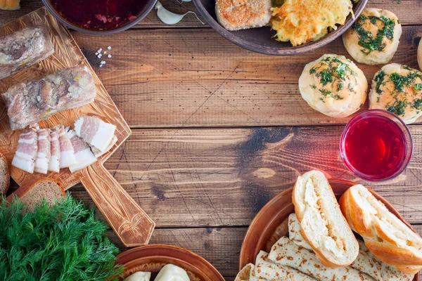 Traditionella rätter i ukrainska rätter på ett träbord - borsch, Niki, pampushki med vitlök, ister, pannkakor, potatis, vvar, ovanifrån, horisontell, kopiera utrymme — Stockfoto