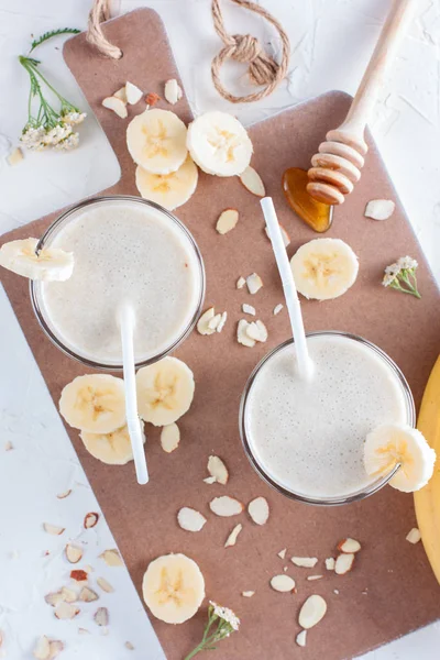 Milk cocktail with banana, almonds and honey, top view, selective focus — Stock Photo, Image