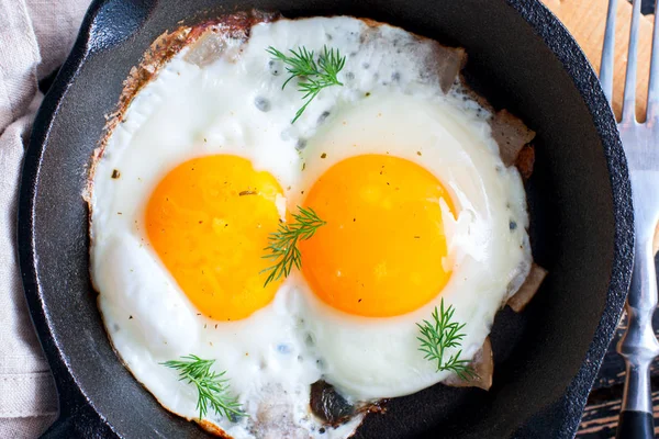 Железные сковородки и яйца с беконом — стоковое фото