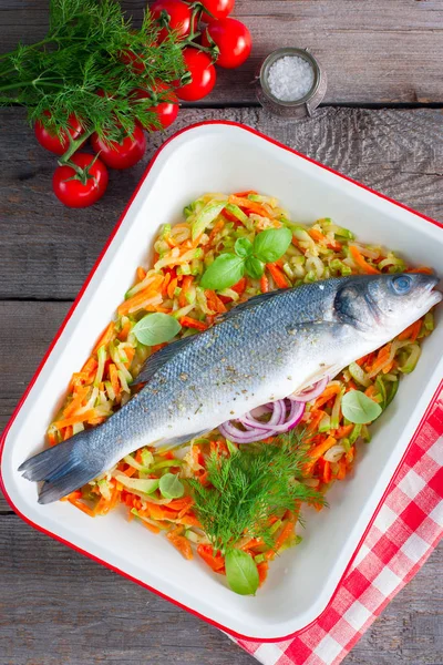 Pescado crudo de lubina en forma esmaltada para hornear con calabacines y zanahorias, vista superior — Foto de Stock