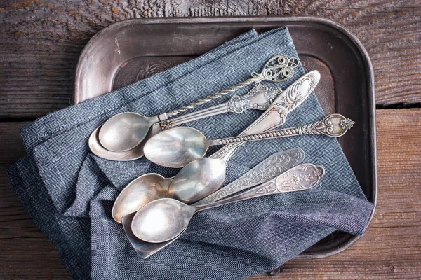 Vintage silver spoons on a tarnished silver tray with retro processing