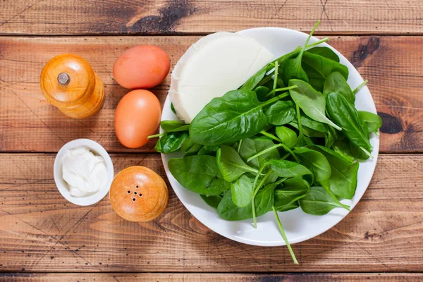 Step by step preparation of spinach salad with eggs and cheese, step 1 - preparation of ingredients, top view, selective focus