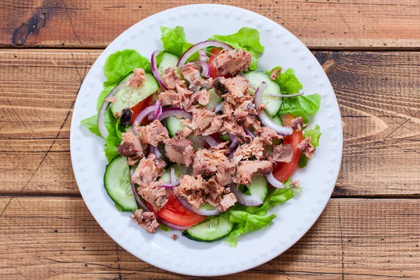 Step-by-step preparation of salad with tuna and fresh vegetables, step 6 - adding canned tuna to the salad, top view