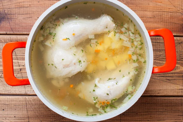 Step by step cooking chicken soup with homemade noodles, step 5 - add chopped potatoes to the soup top view, horizontal