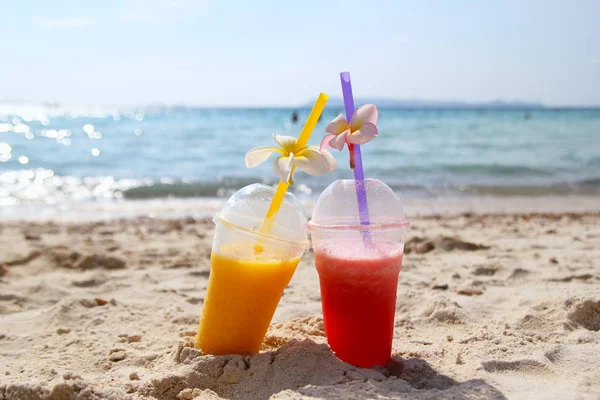 Dois copos com suco de manga e suco de melancia na praia no tempo ensolarado do verão . — Fotografia de Stock