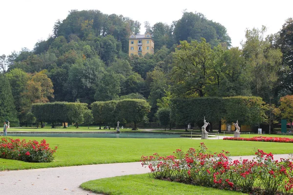 Blick auf den Park in der Nähe des Gebäudes mit bunten Blumen am sonnigen Tag. — Stockfoto