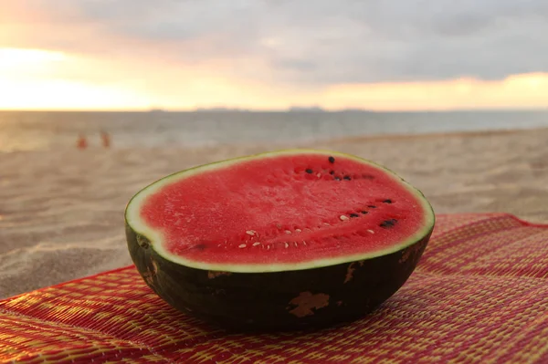 Viaje para Koh Lanta, Tailândia. Uma melancia na praia de areia ao pôr do sol . — Fotografia de Stock