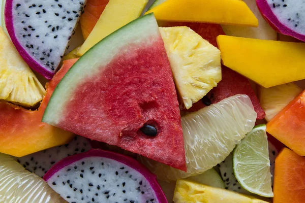 Maturo misto e frutta fresca primo piano per sfondo colorato. Frutta del drago, ananas, papaia, lime, mango, pomelo, rambutan, anguria . — Foto Stock