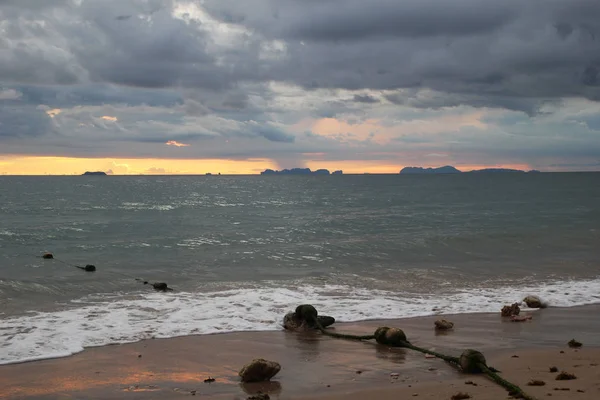 La vista sobre la playa de arena y el cielo nublado al atardecer . — Foto de Stock