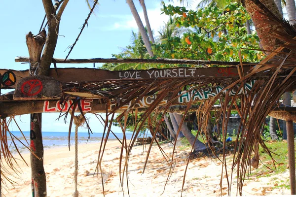 Inscriptions "Love yourself", "Love peace harmony" on the wooden abandoned hut. — Stock Photo, Image