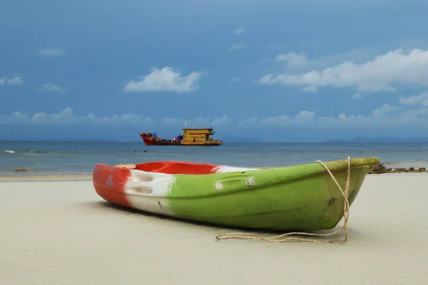 The green-red-white boat on the sand beach with sea and blue sky on background. — Stock Photo, Image