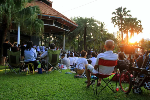 Ludzie słuchają koncertu z królewskiej orkiestry symfonicznej Bangkok Lumpini Park. — Zdjęcie stockowe