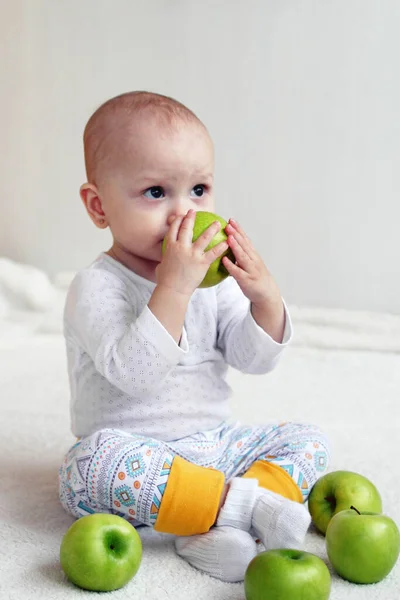 1歳の女の子がアップルを噛もうとしている — ストック写真