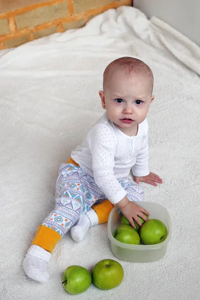 Маленькая Девочка Сидит Белой Клетке Играет Зелеными Яблоками Пластиковом Контейнере — стоковое фото