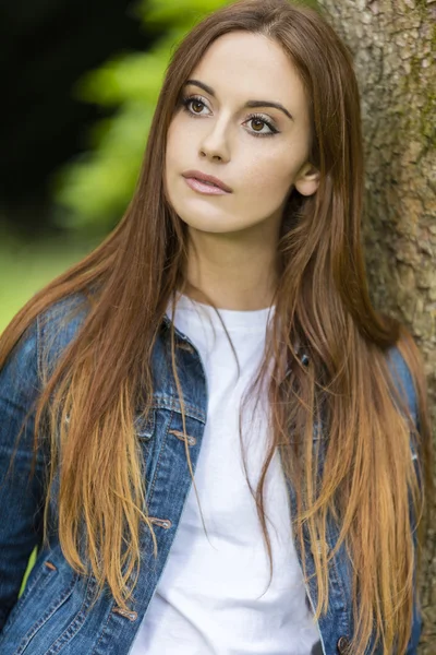 Hermosa mujer joven apoyada contra el árbol —  Fotos de Stock