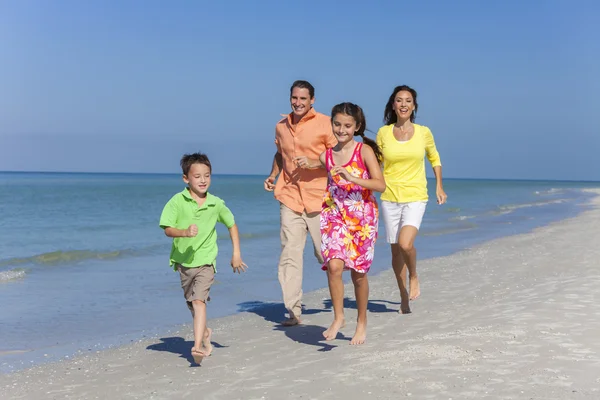 Mutter, Vater und Kinder laufen mit Spaß am Strand — Stockfoto