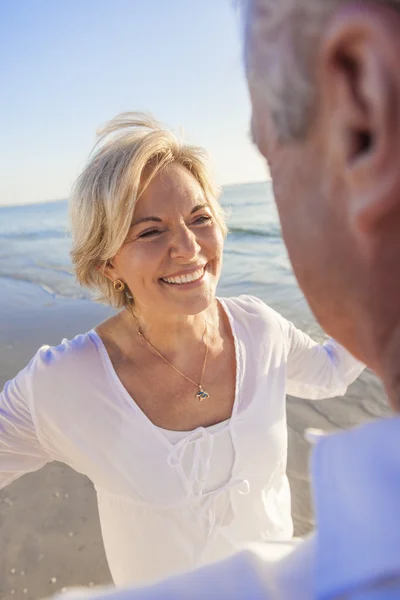 Gelukkige senior paar dansen op een tropisch strand — Stockfoto