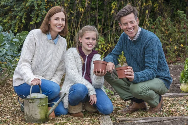 Família feliz menina criança pai mãe filha jardinagem — Fotografia de Stock