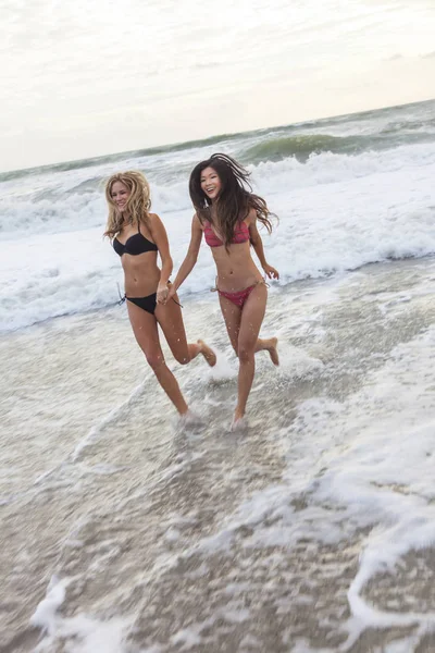 Ragazze giovani donne in bikini in esecuzione sulla spiaggia — Foto Stock