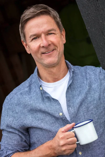 Glücklicher Mann mittleren Alters trinkt draußen Tee oder Kaffee — Stockfoto