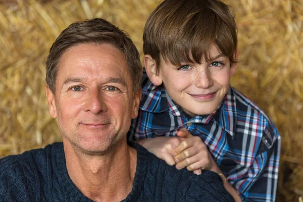 幸せな父の息子男と笑顔干し草の俵の少年 — ストック写真