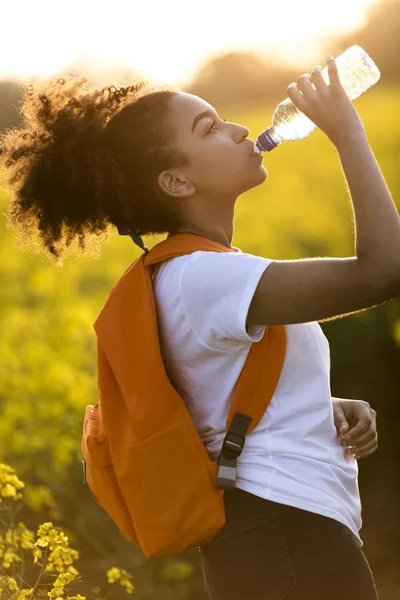 Blandad ras African American Girl tonåring dricksvatten på Solar — Stockfoto