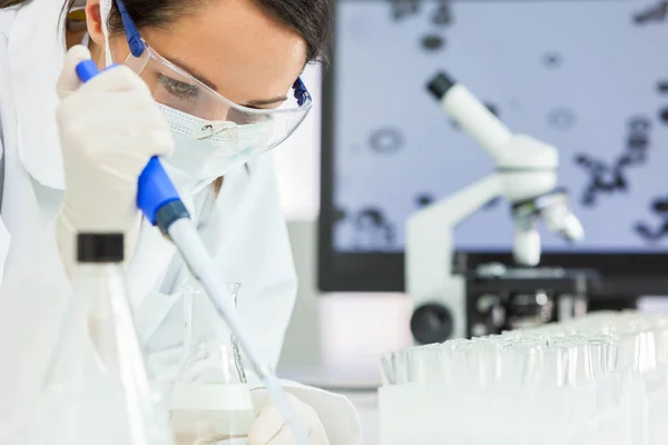 Chercheuse scientifique avec pipette et fiole en laboratoire — Photo
