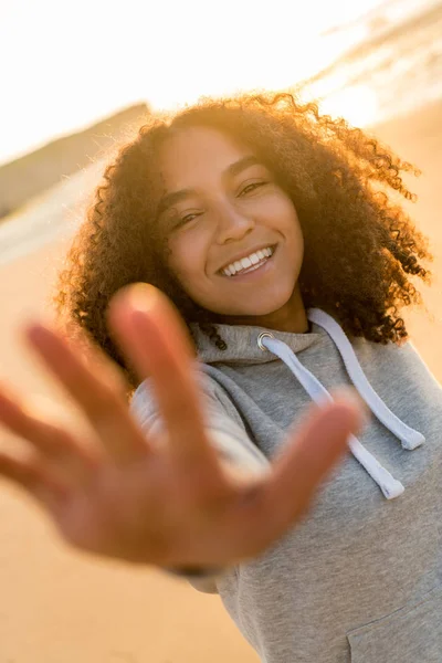 Misturado raça afro-americana menina adolescente sorrindo na praia ao pôr do sol — Fotografia de Stock