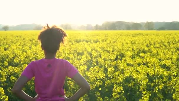 Woman running or jogging and standing in field of yellow flowers — Stock Video